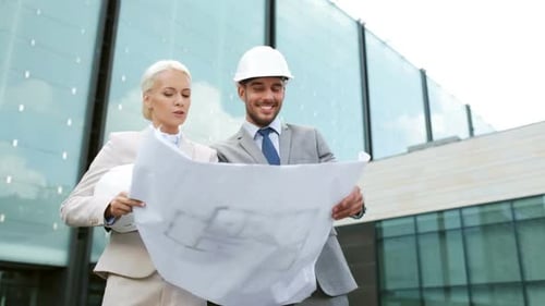 Architects Consulting Blueprints Outside Modern Building