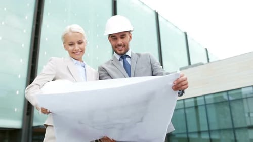Smiling Architects Reviewing Building Plans Outdoors