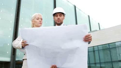 Architects Reviewing Building Plans Outside Office Building
