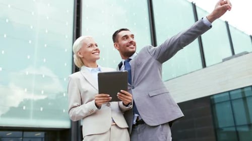 Business Colleagues Viewing Tablet Outside Office Building