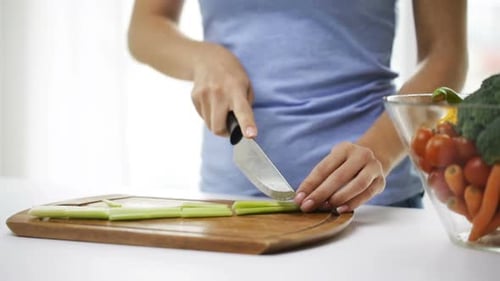 Close Up Of Young Woman Chopping Celery At Home 2