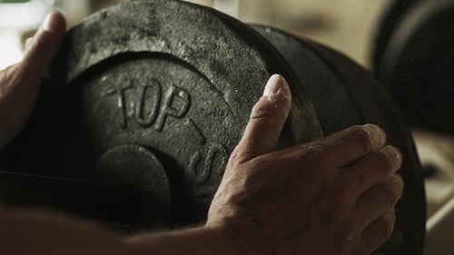 Athlete Putting Weights On Barbell