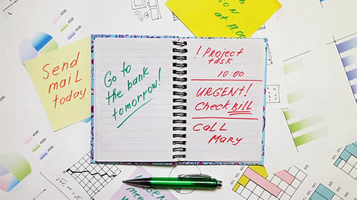 Open Notebook Surrounded by Papers with Charts