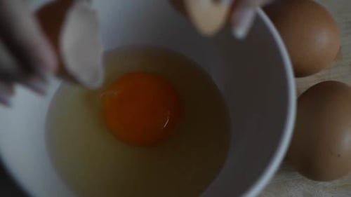 Cracking an Egg into a Bowl in Kitchen