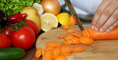 Slicing Carrots with Vegetables on Cutting Board