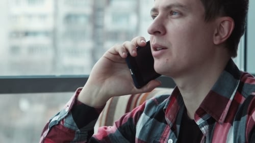 Smiling Man Talks on Phone Indoors