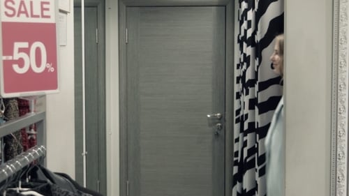 Two Girls Try On a Coat In a Locker Room