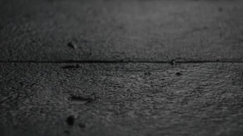Raindrops Falling on Wet Urban Tile at Night