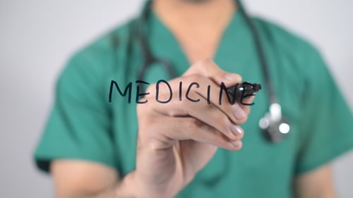 Medical Professional Writes Medicine on a Clear Surface