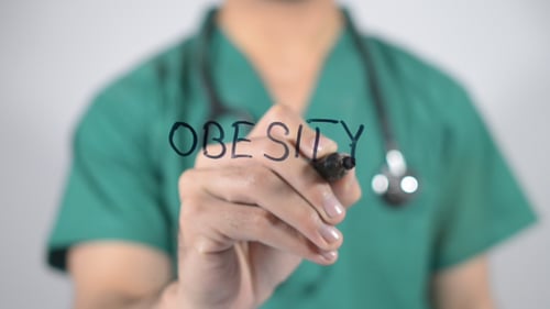 Medical Professional Writes Obesity Close Up