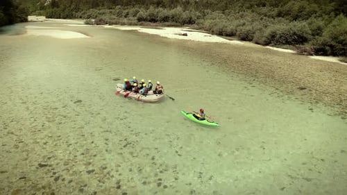 Luftaufnahme einer Gruppe von Sparren, die Rafting machen und den Fluss Soca hinunterfahren.