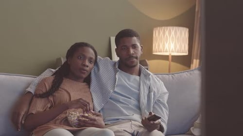 Couple Relaxing on Couch at Home, Watching TV