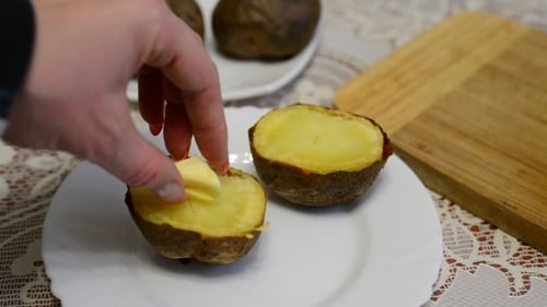 Woman Adds Butter In Baked Potatoes
