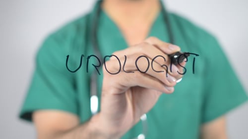 Doctor Writing 'Urologist' on Glass in Hospital