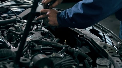 Mechanic Fixing Car Engine with Tools