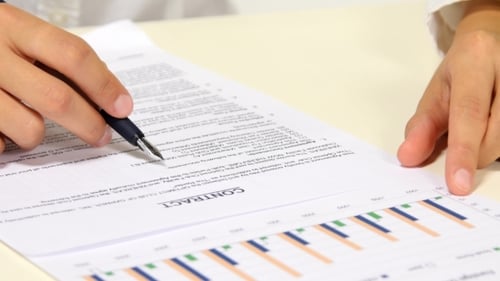 Hands Pointing at Contract with Pen and Graph