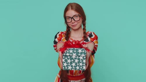 Teen Giving Gift in Front of Blue Backdrop