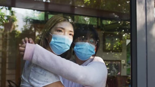 Young Adult and Teen Embrace Wearing Face Masks