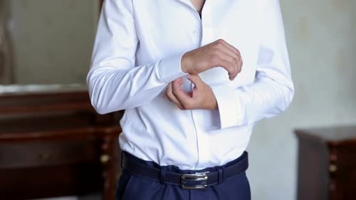 Man Adjusts His Shirt Cuff Before Wedding