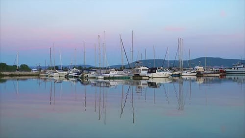 A Quiet Seascape, a Little Yacht with a Lowered Stand in the Port in the Evening