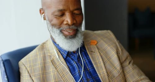Older Man Listening to Music on Phone Indoors