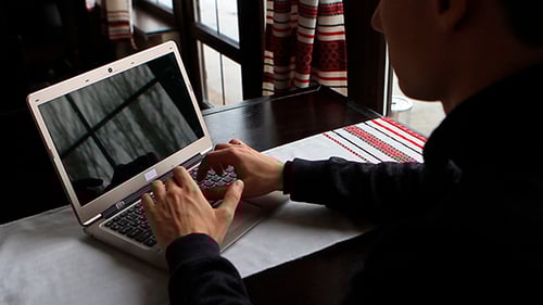 Homme tapant sur un ordinateur portable