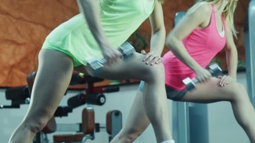 Women Doing Dumbbell Exercises Together in Gym