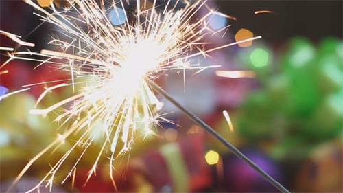 Festive Sparkler Ignites with Twinkling Background Lights