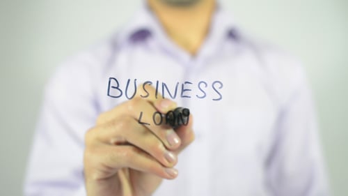 Writing Business Loan on Glass in an Office