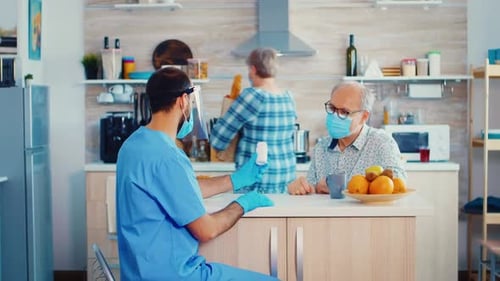 Medical Professional Consults with Senior Man in Kitchen