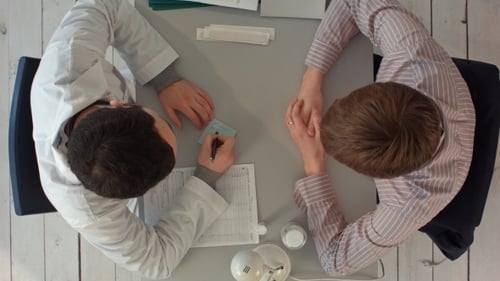 Top View Of Doctor Writing On a Medical Chart
