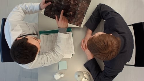Doctor Reviews Brain Scan with Patient in Office