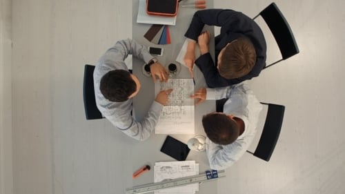 Architekten mit Bauplan auf der Baustelle