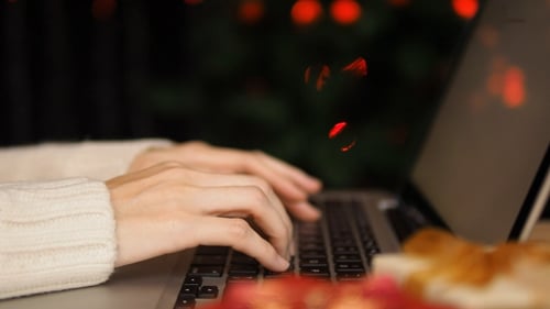 Typing on Laptop with Christmas Lights in Background