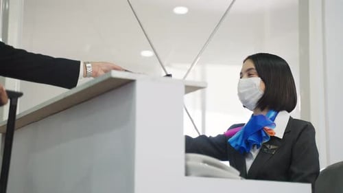 Airline Employee Helping Traveler at Airport Check-in Counter
