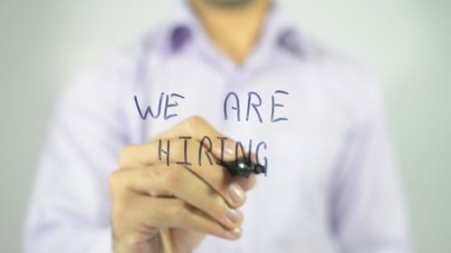 Hand Writes 'We Are Hiring' with Black Marker