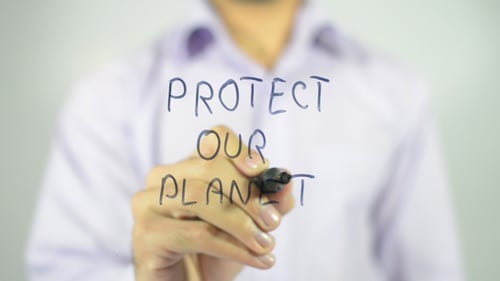 Man Writing 'Protect Our Planet' on Glass
