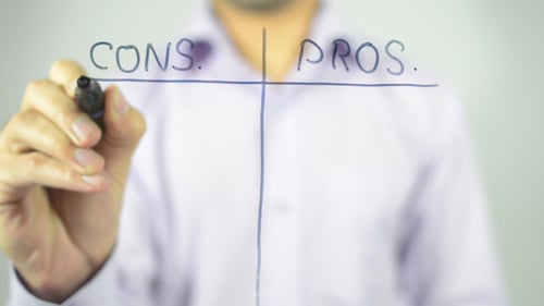 Hand Writing Pros and Cons Matrix on Glass