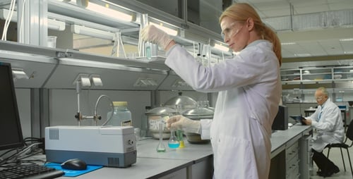 Scientist Working in Laboratory Pouring Blue Liquid