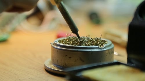Soldering Circuit Board on Wooden Desk Close Up