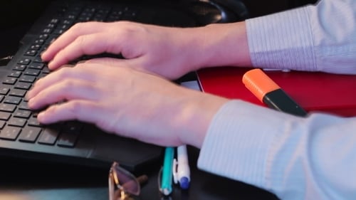 Man Typing on Black Laptop Keyboard in Office