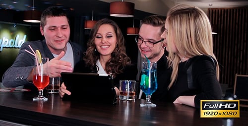 Adults Laughing Together Viewing Tablet at Bar