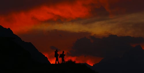 Silhouetted Figures at Sunset in the Mountains