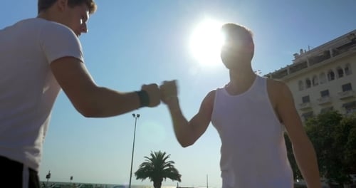 Young Men Greet with Fist Bump and Embrace