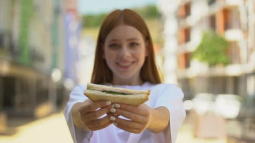 Woman Offers a Sandwich in the City