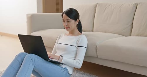 Woman Using Laptop Sitting on Floor Indoors