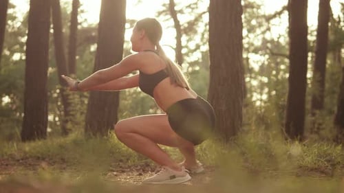 Woman Doing Squats in Forest at Sunrise