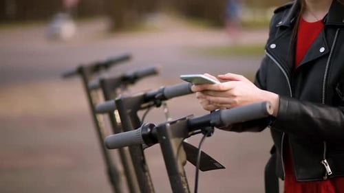 Woman With Phone Near Electric Scooters