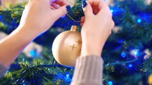 Decorating Christmas Tree With Ornament and Lights