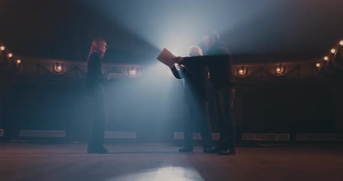 Actors Rehearsing on Theater Stage with Director